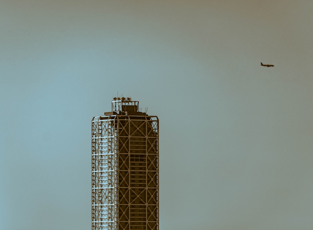 Commercial airliner flying above a hotel building, representing the partnership between Delta Air Lines and Hyatt Hotels.