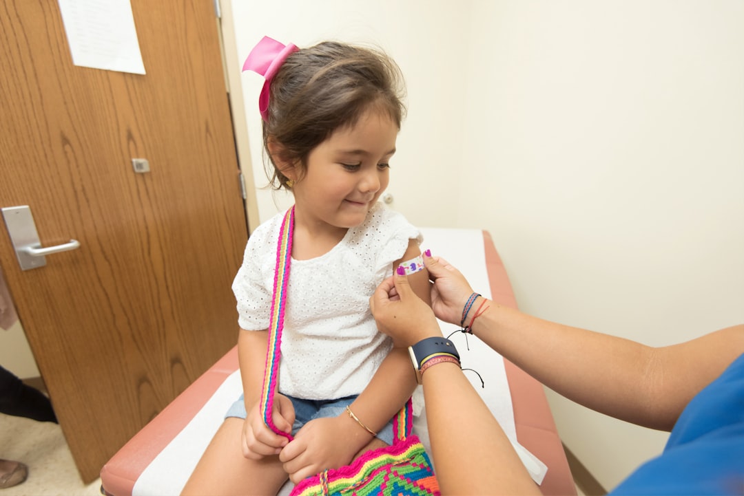 Healthcare worker administers a vaccine to a young child in a clinic setting.