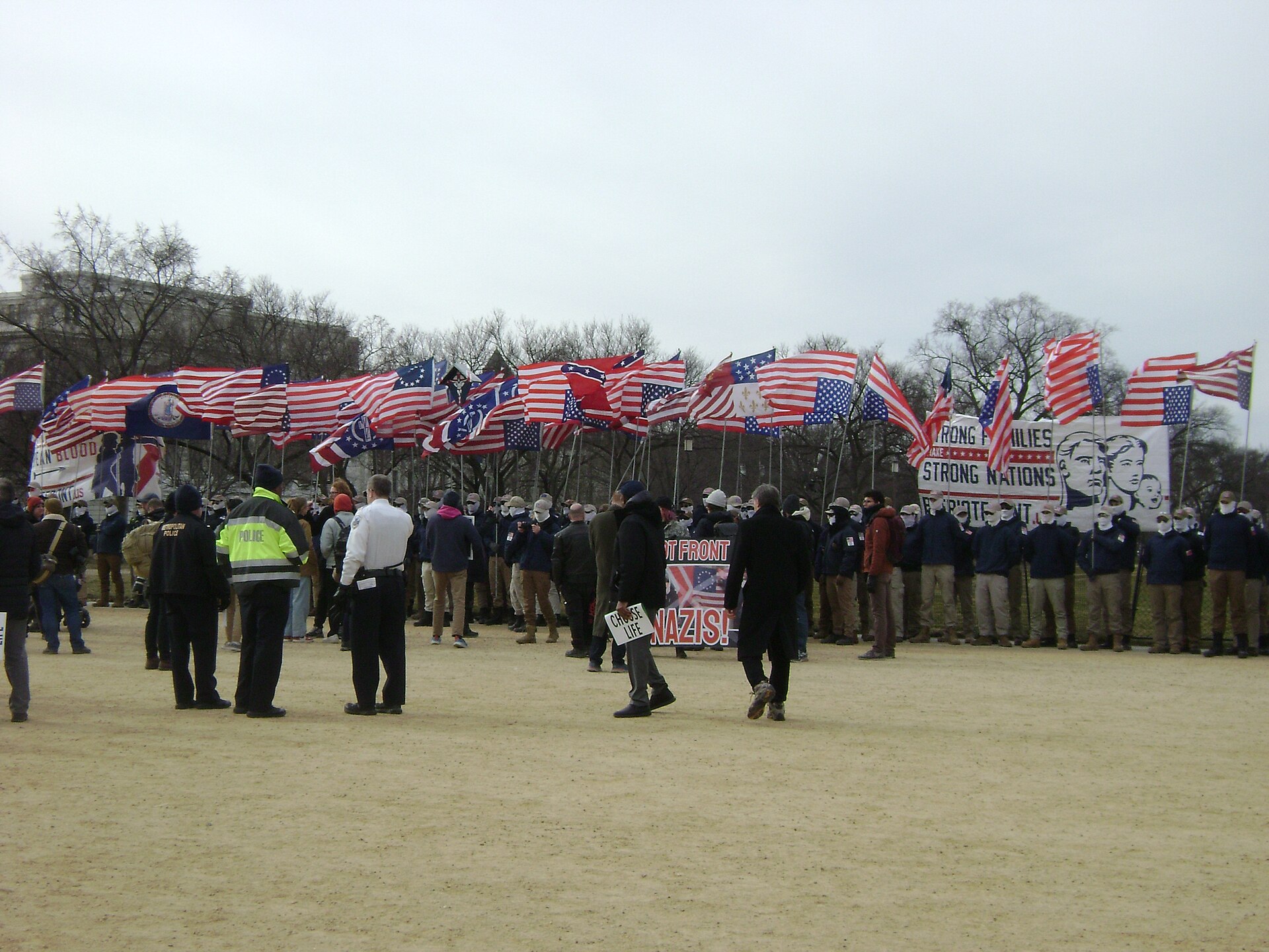 Masked members of the white nationalist group Patriot Front marching in formation with flags and shields through Washington, D.C.