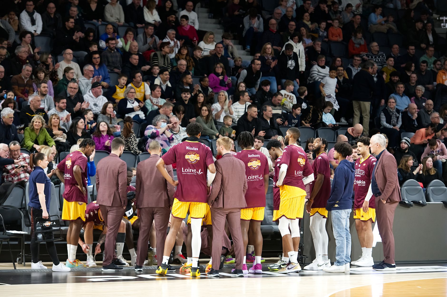 Team USA basketball players gathered in a huddle on the court during an international game.