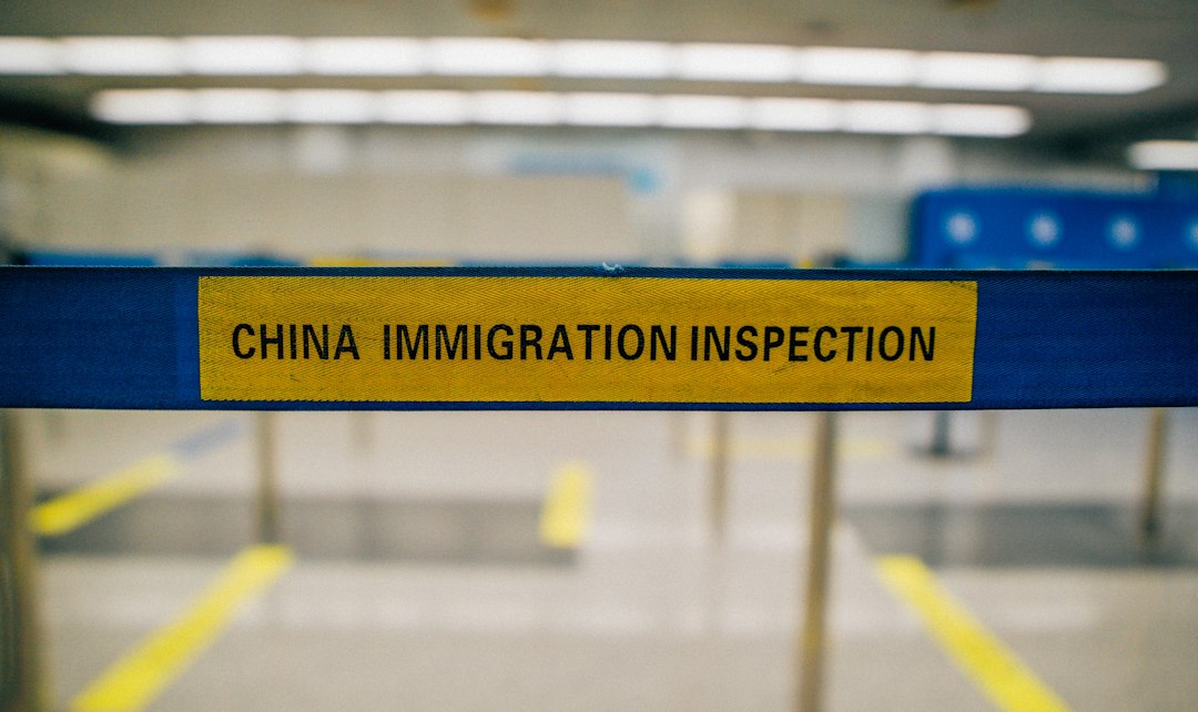 Federal immigration officers escort a detained migrant through an airport during deportation proceedings, illustrating concerns over deportations to third countries.