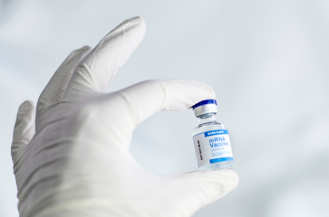 A vial of measles vaccine with a syringe on a medical tray
